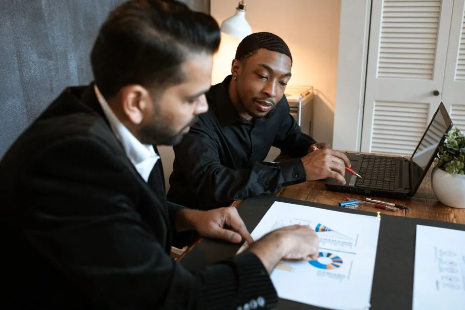 Two coworkers work together on a marketing plan at a whiteboard, with a focus on user-generated content.